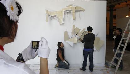 El artista sevillano Rodrigo Martín Freire, de espaldas, con su obra.