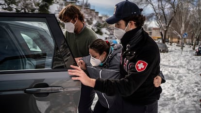 Volunteers Miguel and Rodrigo helping Triana into a car before driving her to La Paz hospital in Madrid.