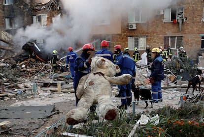 Equipos de rescate trabajan en un edificio de apartamentos alcanzado por misiles rusos este jueves en Kiev.