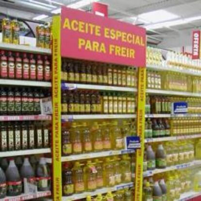 Estantería de un supermercado con botes de aceite especial para freir