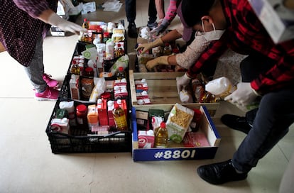 Voluntarios de la Red de Cuidados de Moratalaz preparan cestas de comida para repartir entre los más necesitados.