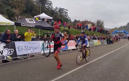 Ismael Esteban carries his bike as opponent Agustín Navarro follows.