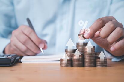 Businessman putting coin stacking with up arrow and percentage sign for increase financial interest rate and business investment growth from dividend concept.