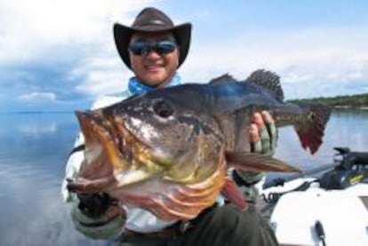 Un pescador muestra su trofeo en R&iacute;o Negro, Amazonas.