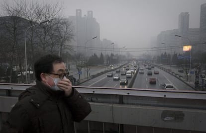 Un hombre usa mascarilla para protegerse de la contaminación en Pekín