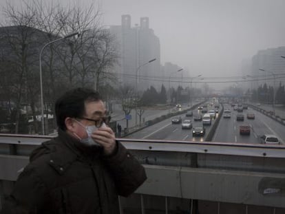 Un hombre usa mascarilla para protegerse de la contaminaci&oacute;n en Pek&iacute;n