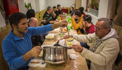 Lagarder Danciu, con un jersey azul, sirve sopa a una persona en el comedor de Welcome Sense Sostre Barcelona.