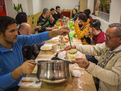 Lagarder Danciu, con un jersey azul, sirve sopa a una persona en el comedor de Welcome Sense Sostre Barcelona.