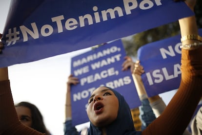 Una mujer de religión musulmana participa en la manifestación con un cartel contra el terrorismo.