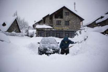 Un hombre intenta desenterrar su coche en Benasque, tras la gran nevada caída en el Pirineo.