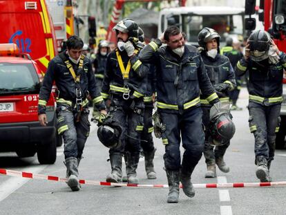Los bomberos salen de las labores de rescate, en una imagen de este jueves.
