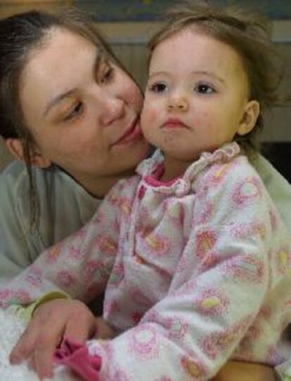 Erika, en los brazos de su madre, en el hospital de Alberta, el martes.