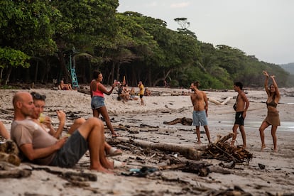 Algunos turistas y residentes se reúnen en un bar frente a la playa para ver la puesta de sol, uno de los principales atractivos de la pequeña localidad playera de Santa Teresa, en la costa pacífica norte de Costa Rica. Una cerveza de producción local en uno de estos bares puede costar entre cinco y ocho euros.