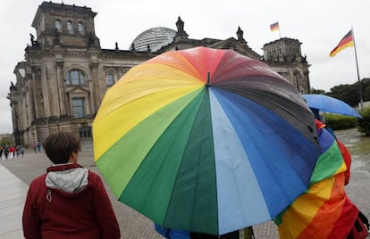 Varias personas sostienen paraguas con el arco iris ante el Parlamento en Berlín (Alemania), el 30 de junio de 2017.