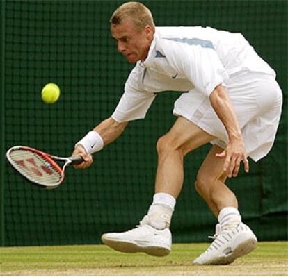 El australiano Hewitt devuelve una pelota en su partido frente al británico Henman.