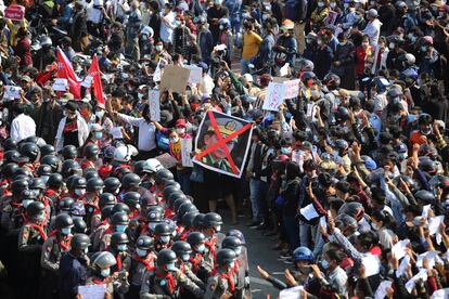 Manifestantes protestan contra el golpe de Estado en la ciudad birmana de Naypyidó, el pasado 8 de febrero. En una pancarta, el rostro del general Min Aung Hlaing tachado.