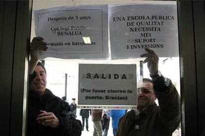 Dos personas protestan por retrasos en colegios, ayer en Alicante.