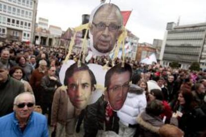 Miles de personas se manifiestan por las calles de Ferrol en demanda de contratos que permitan reanudar la actividad industrial en el sector naval. En la imagen los retratos del ministro de Hacienda, Cristóbal Montoro; el alcalde de Ferrol, José Manuel Rey (i), y el presidente de la Xunta de Galicia, Alberto Núñez Feijóo, colgados de una caña de pescar en la plaza de Armas, lugar en el que finalizó la marcha.