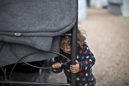 Una niña refugiada de dos años intenta esconderse tras una valla, en el campo de refugiados de Ritsona (Grecia).