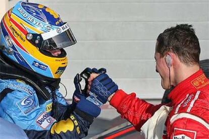 Fernando Alonso y Michael Schumacher se saludan tras la carrera.