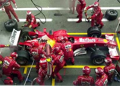 Los mecánicos se apresuran a apagar un incendio en el Ferrari de Michael Schumacher durante un repostaje.