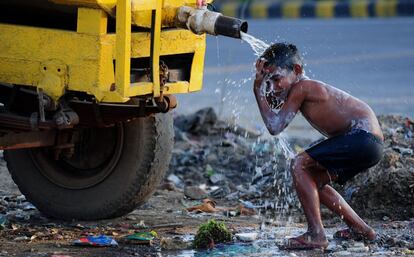 Un niño indio se lava en un tanque de agua en la ciudad de Faridabad, un suburbio de Nueva Delhi.