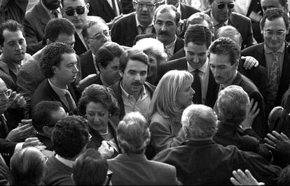 José María Aznar, acompañado por Eduardo Zaplana y Rita Barberá, rodeado por una multitud, a la entrada del Palau de Música de Valencia durante la convención del Partido Popular en 1994.