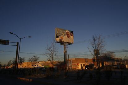 Un cartel gigante con la imagen del Papa Francisco y un mensaje que dice "Juárez es amor, estamos listos" en Ciudad Juárez.