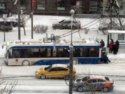 Los pasajeros empujan un trolebús atascado por la nieve en Moscú.