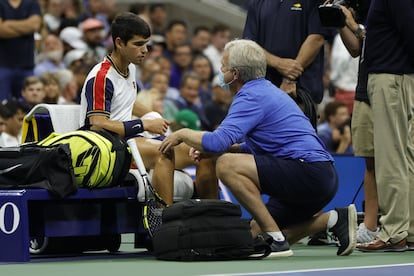 Carlos Alcaraz es atendido por el médico durante el partido contra Augger-Aliassime en la pista Arthur Ashe.