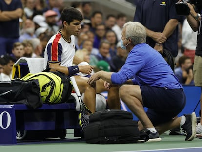 Carlos Alcaraz es atendido por el médico durante el partido contra Augger-Aliassime en la pista Arthur Ashe.