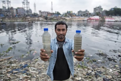 Un bangladesí con dos muestras de agua recogidas en dos puntos del Buriganga.