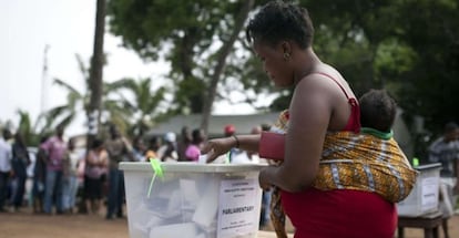 Una mujer vota con su hijo a la espalda durante las elecciones de Ghana en 2012.