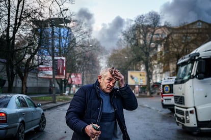 A wounded man stands on a street after Russian shelling in Kherson, December 24, 2022.