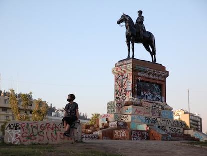 Una mujer descansa junto a la estatua a Manuel Baquedano cuando estaba en Plaza Italia, en Santiago (Chile).