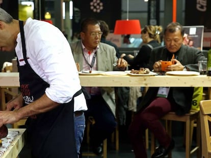 Un cocinero prepara un plato en un expositor de Alimentaria.