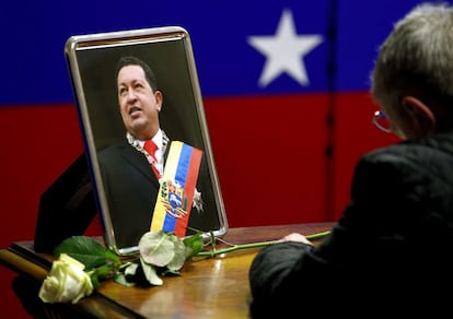 Un hombre escribe en el libro de condolencias en la embajada de Venezuela de la ciudad de Berlín.