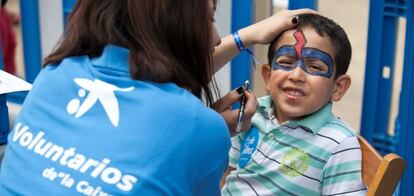 Una voluntaria de la Obra Social La Caixa, participa en una actividad lúdica con niños.