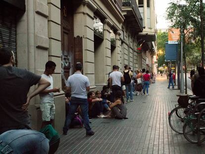 Varias personas hacen cola para tramitar el DNI y el pasaporte en Barcelona, en una foto de archivo.