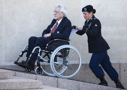 Una soldado ayuda a un veterano de guerra para asistir a la ceremonia franco-estadounidense en el cementerio militar estadounidense de Coeville-sur-Mer, Francia.