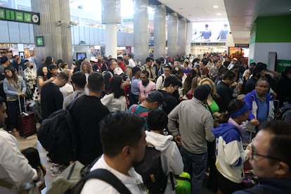 Pasajeros esperan en el Aeropuerto Internacional Benito Juárez debido a una interrupción tecnológica mundial que causó retrasos en los vuelos, en Ciudad de México.