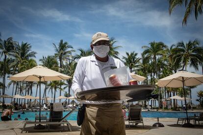 Un mesero atiende a los turistas del hotel Princess Mundo Imperial tomando las medidas sanitarias establecidas por la Secretaría de Salud para prevenir contagios de la covid-19. En el hotel la precaución es extrema.