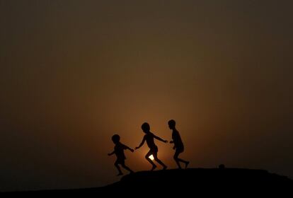Unos niños juegan durante la puesta del sol en la ciudad de Agartala (India).