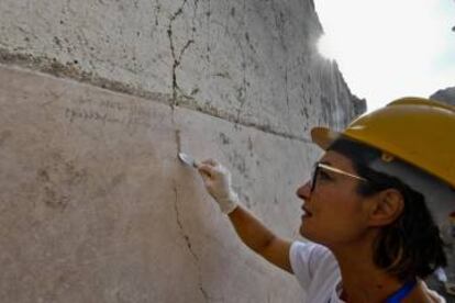 Una arqueóloga muestra la inscripción hallada.