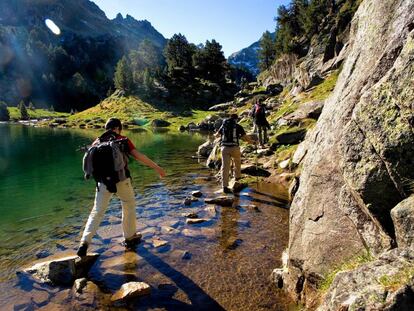 Senderistas en el lago Redon, dentro del parque nacional de Aigüestortes i Estany de Sant Maurici, en el Valle de Arán (Lleida).