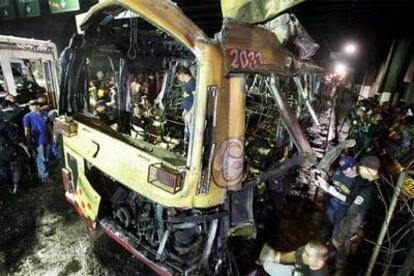 La policía filipina inspecciona los restos del autobús que explotó en el distrito financiero de Manila.