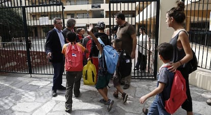 Niños refugiados a la entrada de un colegio en Atenas.