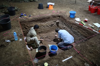 Researcher Tim Maloney (right) excavates with a colleague at Liang Tebo Cave