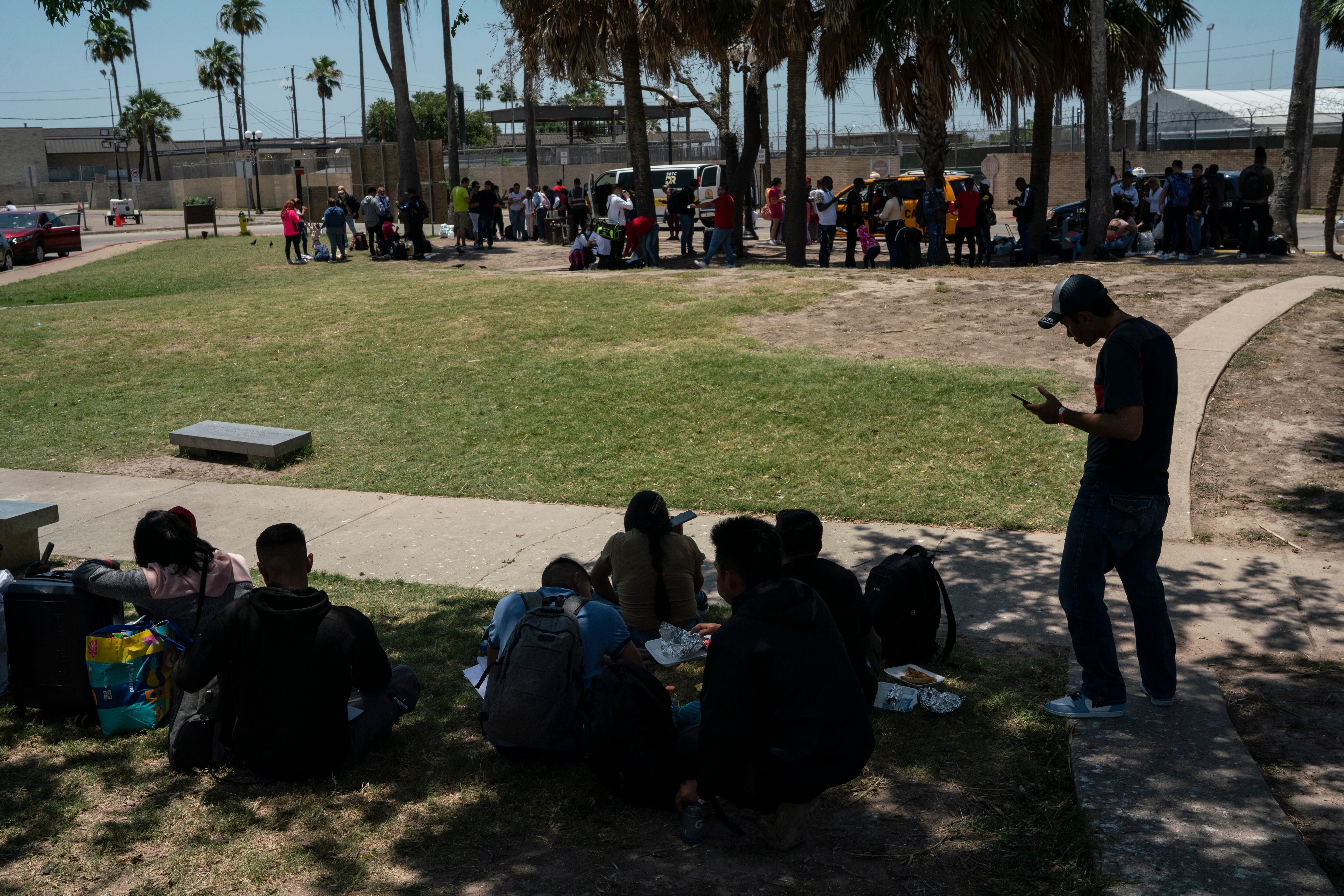 Migrantes que acaban de ingresar legalmente en Estados Unidos por medio de la aplicación CBP One hacen tiempo en una plaza en Brownsville antes de decidir su destino final. 