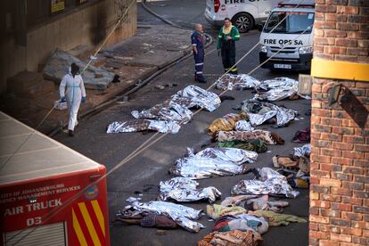 Personal sanitario observa los cuerpos de las víctimas del siniestro en el centro de Johannesburgo.